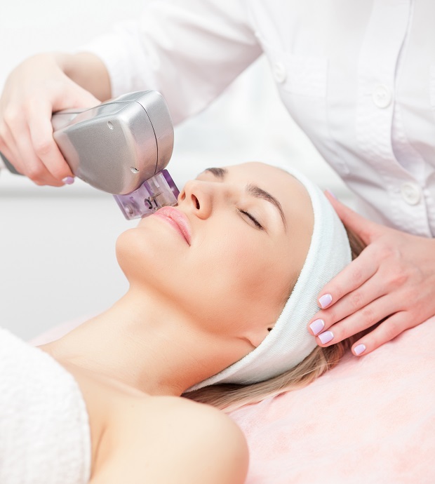 Cheerful,Beautician,Is,Undergoing,Laser,Treatment,For,Female,Face.,She